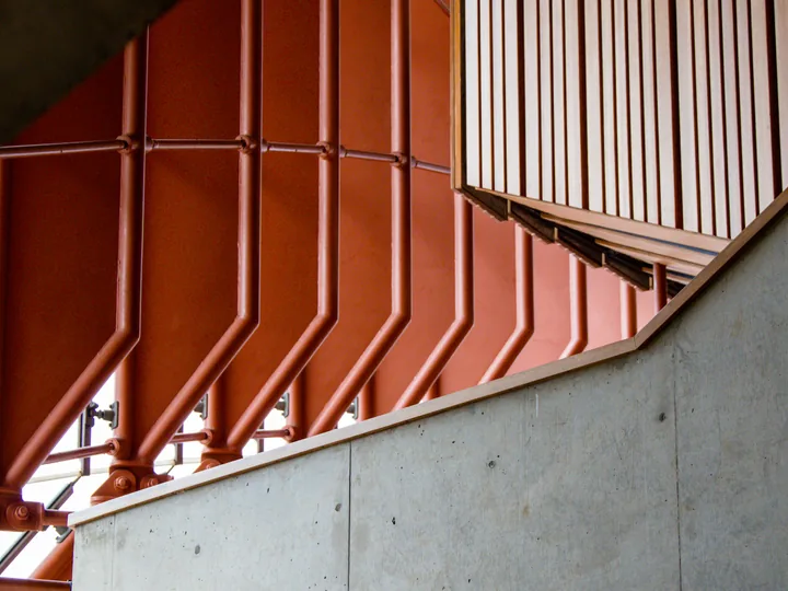 Orange structural lines frame a modern concrete facade.